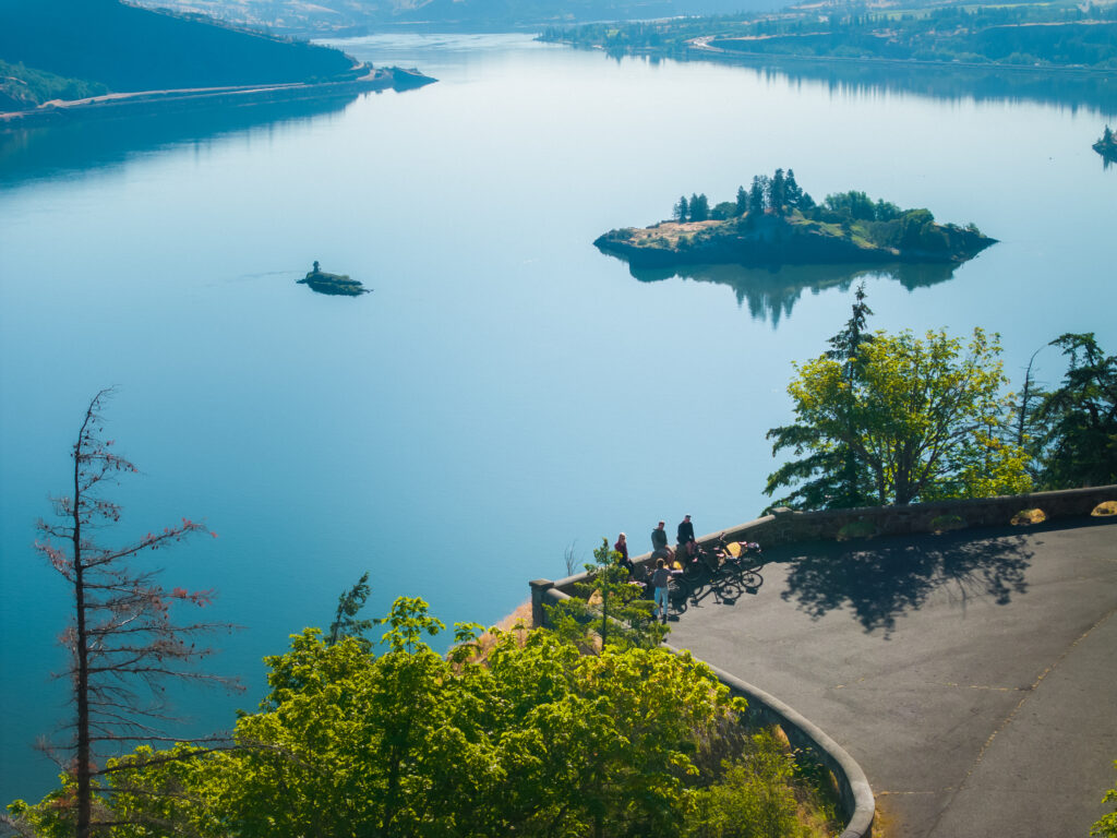 Group of e-bike riders taking in panoramic Columbia River Gorge views from a scenic overlook on a Hood River e-bike tour.
